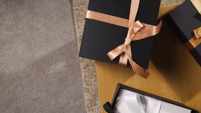 Close up hand opening luxury black gift box ribbon bow