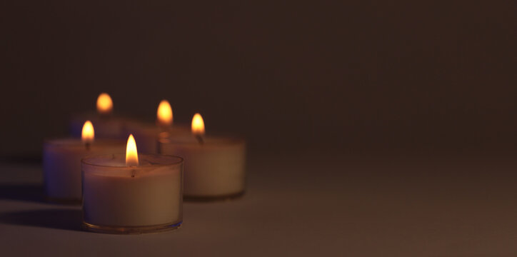 Soft focus. blur Burning candles in dark. Evening, night Light and shadow brown background. Minimalist still life.