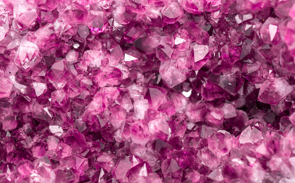 Amethyst pink crystals. Gems. Mineral crystals in the natural environment. Texture of precious and semiprecious stones. Seamless background with copy space colored shiny surface of precious stones.