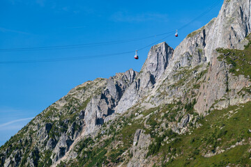 Gondola lift crossing a steep rocky mountainside under clear blue summer sky in the French Alps near Chamonix. © Andrei Tomas