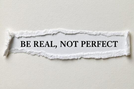 Be real, not perfect text appears on torn white paper against a neutral background. Motivational quote, self acceptance, authentic living.