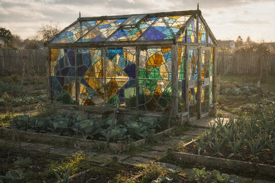 Stained Glass Greenhouse Glowing in an Autumn Vegetable Garden