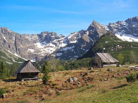 Traditional Wooden Huts in Tatra Mountains with Snow Covered Peaks Poland
