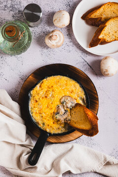 Mushroom julienne with cream and cheese crust in a frying pan on the table top and vertical view