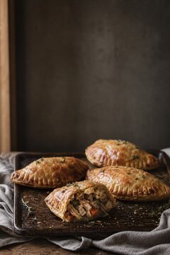 Homemade meat pies on rustic tray. Savory pastry filled with meat and vegetable for Thanksgiving dinner.
