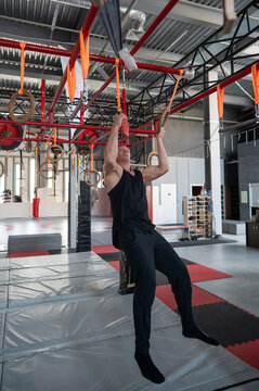 An athletic man practices at a ninja club's indoor obstacle course.