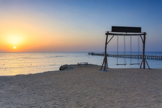 Wooden swing over the Red Sea in Marsa Alam at sunrise, Egypt