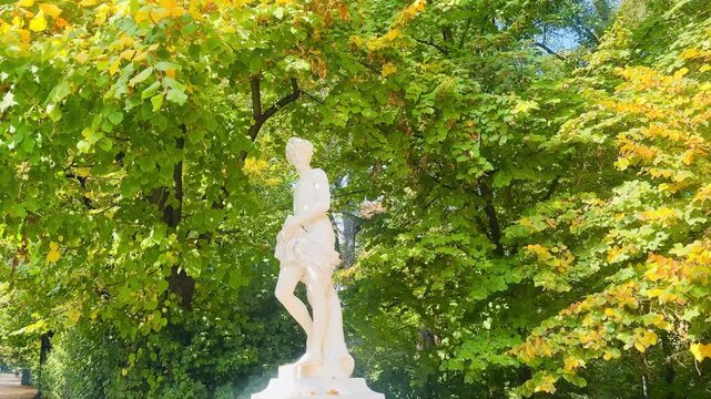 Italy, August 17, 2025.
Classical female statue surrounded by lush trees as autumn leaves gently fall in a peaceful garden, creating a serene seasonal atmosphere..
Author: Djundiet A.