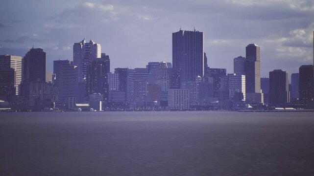 Evening San Francisco skyline with lights, bay edge reflecting urban glow. Highrise window lights and subtle reflections evoke business, nightlife, and commuter
