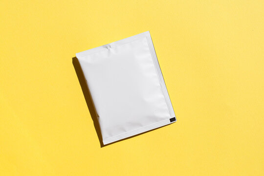 Blank craft plastic pouch, white pack on studio background with shadow, mylar bag isolated for coffee or food, cosmetic products, snack, candy. Different sizes, mock up.
