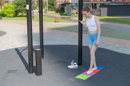 A woman with cerebral palsy walks on sensory mats. Rehabilitation