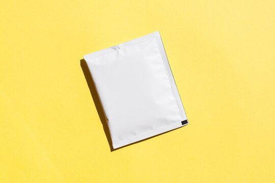 Blank craft plastic pouch, white pack on studio background with shadow, mylar bag isolated for coffee or food, cosmetic products, snack, candy. Different sizes, mock up.