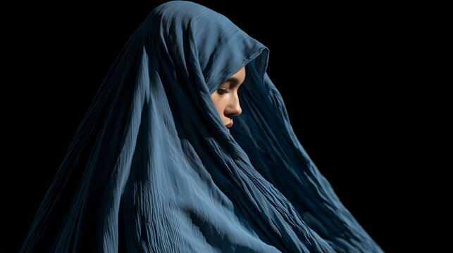 Woman wearing a traditional blue burqa standing against a dark background, symbolizing culture, identity, and the complex layers of tradition and privacy. Afghan culture, burqa por
