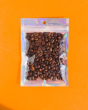 Blank craft plastic pouch mock up with coffee beans inside, transparent pack on studio background with shadow, mylar bag isolated for coffee product