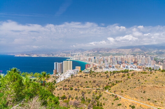 Aerial panoramic view of Old town Benidorm city historic centre coastline with skyscraper buildings on Costa Blanca coast Mediterranean Sea and Sierra Cortina mountain range in summer day, Spain