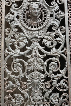 Grille de porte ancienne en fonte avec visage de femme