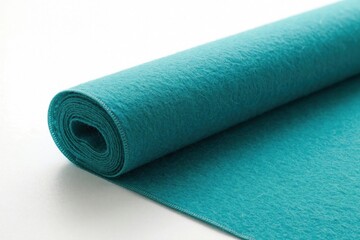 Obraz premium Blue felt fabric roll on white background. Sea green textile material twisted in spiral shape. Soft texture for arts, crafts projects. Close up of colorful cloth for sewing, fashion design, DIY home