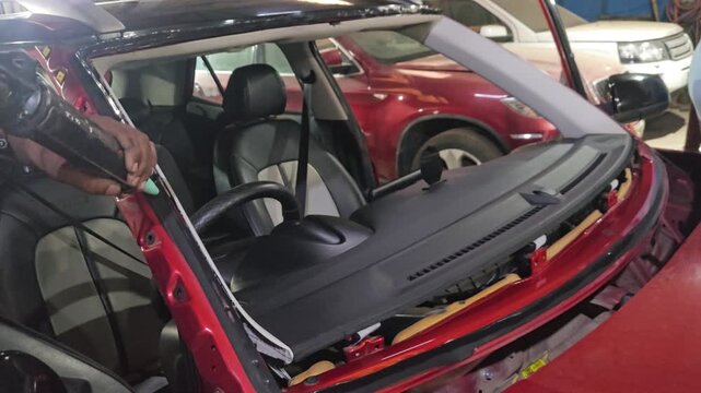 Professional Technician Removing and Installing Front Windshield Glass on Red Car in Automotive Workshop, Windshield Replacement Service, Auto Glass Repair, Vehicle Maintenance and Car Repair