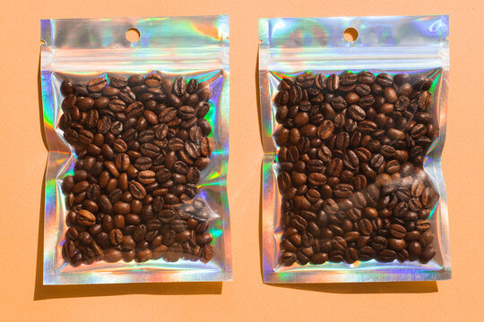 Blank craft plastic pouch mock up with coffee beans inside, transparent pack on studio background with shadow, mylar bag isolated for coffee product