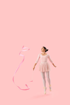 Young woman with ribbon doing rhythmic gymnastics on pink background
