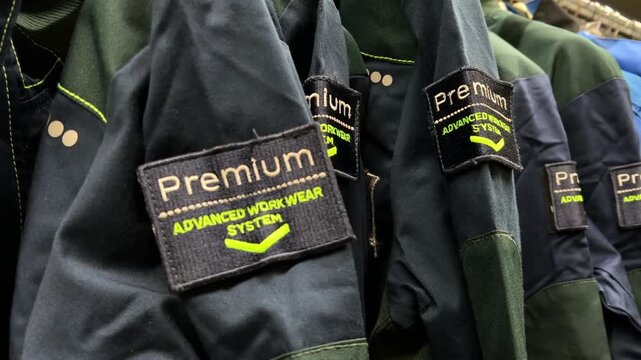 Close-Up View: Premium Workwear Jackets Hanging on Store Rack | Industrial Protective Clothing with Advanced Work Wear System Patches | Retail Safety Apparel Display