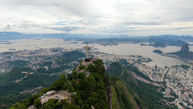 Aerial view of Christ the Redeemer statue atop Corcovado mountain overlooking the urban landscape, Guanabara Bay, and Sugarloaf Mountain in Rio de Janeiro, Rio de Janeiro, Brazil.