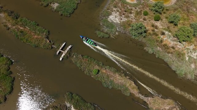 Aerial view of a small boat navigating through the winding waterways of the Karavasta Lagoon in Divjake, Fier County, Albania.