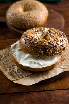 Bagel with cream cheese on wooden table