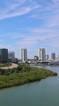 Cruise ship leaving Tampa on Caribbean Vacation. Panoramic view of the downtown Tampa Florida skyline over calm water with lush green mangroves and coastal buildings in USA