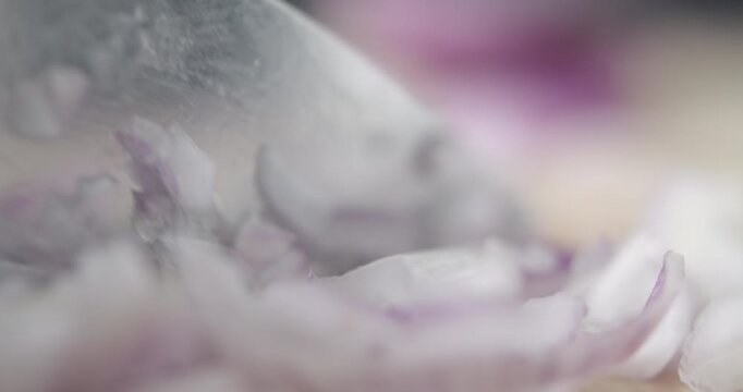 Tabletop Macro Close up of kitchen knife chopping onions in slow motion