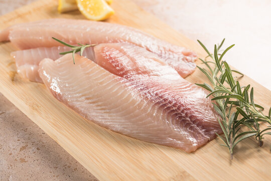 tilapia fillet with a slice of lemon and rosemary