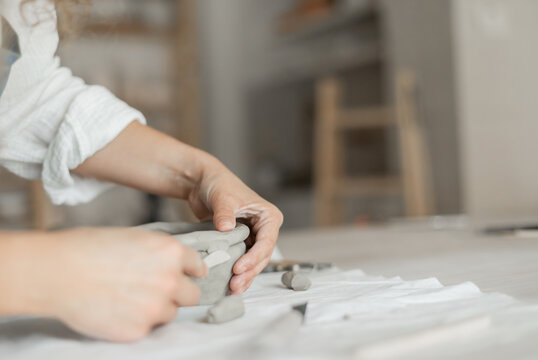 Woman potter meticulously shaping clay in a studio setting