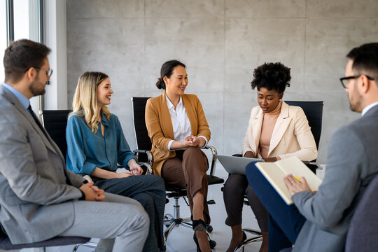 Multicultural professional businesspeople working together on research plan in boardroom.