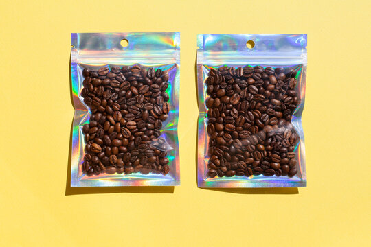 Blank craft plastic pouch mock up with coffee beans inside, transparent pack on studio background with shadow, mylar bag isolated for coffee product