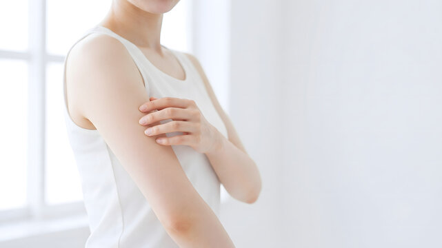 二の腕の素肌を優しくケアする女性のボディケア・スキンケアイメージ