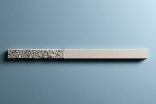 A long rectangular bar split into two textures, one side rough and rocky, the other smooth and flat, set against a solid light blue background
