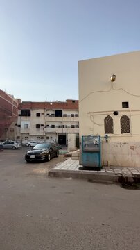 Street view showing the exterior, ornate gates, and minaret of Masjid Bani Haram in Medina.