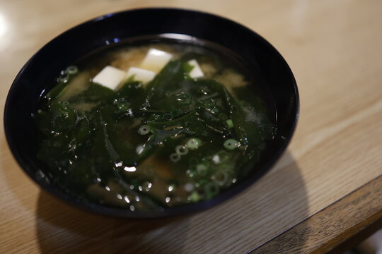 わかめたっぷりの味噌汁。豆腐入り。黒い器。和食。