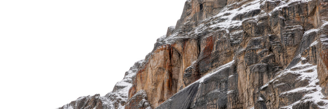 Snow dusted mountain rock face during overcast daylight with rough textured terrain