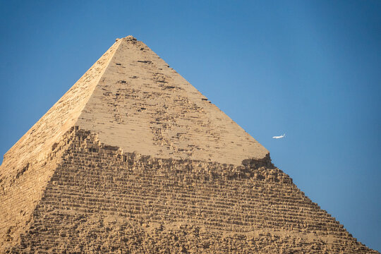 Plane flying past a pyramid in the Giza Pyramid Complex in Cairo, Egypt