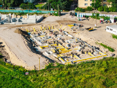 Aerial view of a residential construction site at 4A Cieceres Street in Agenskalns, featuring concrete foundations and yellow formwork near Maras Pond in Riga, Latvia.