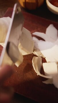 Close-up of slicing bamboo shoots on a wooden cutting board.