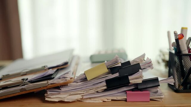 Business Records and Stacked Documents Organized with Binder Clips on Desk