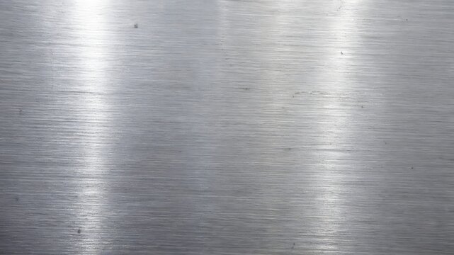 Brushed stainless steel metal texture background with horizontal grain and bright light reflections background stainless industrial