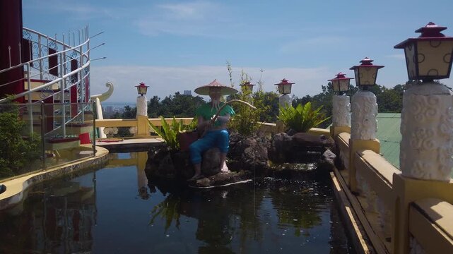 Cebu Taoist Temple - Sculpture of Lao Tzu Fishing in The Pond - Philippino Chinese Community Shrine Complex -  MS LS 4K UHD