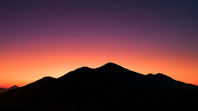 Silhouette of Mountain Range Against Vibrant Sunset Sky