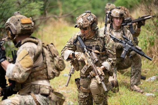 Team of military soldier army force having brief planning for engage and rescue mission using map for actual field operation, peace and conflict resolution concept