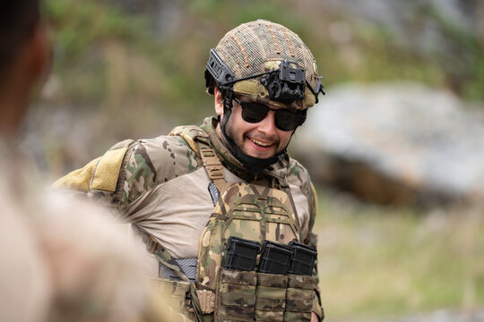 Young military soldier is smiling during field operation in dangerous battlefield for peace and conflict resolution