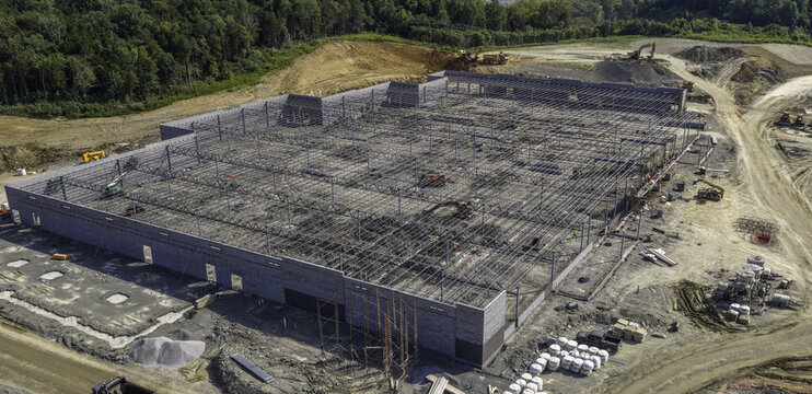 Aerial view of a large industrial warehouse distribution facility under construction with steel framing and heavy machinery on site in Mt. Juliet, Tennessee, United States.