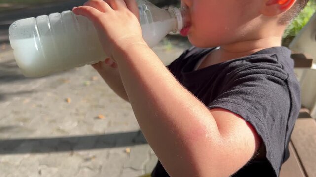 汗をかいている子供が水分補給する様子